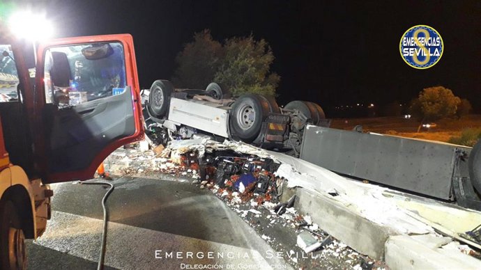 Bomberos rescatan al conductor de un camión en la SE-30 tras el vuelco de su vehículo.