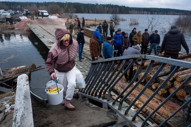 Civiles ucranianos escapan de los combates en Ucrania a través del río Irpin 