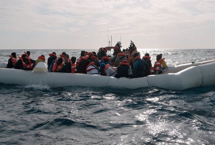 Archivo - HANDOUT - 26 December 2021, Italy, ---: Migrants in a distressed boat shovel water out of the boat while the rescue team of the private aid organization Sea-Watch takes the people on board the Sea-Watch 3 vessel. Among the rescued was also a h
