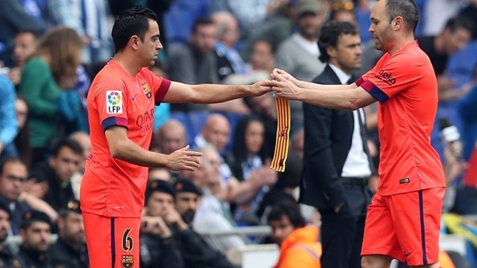 Archivo - Xavi recibe el brazalete de capitán de manos de Iniesta en un partido en 2015.