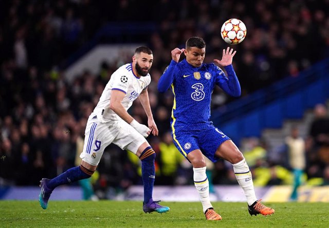 06 April 2022, United Kingdom, London: Real Madrid's Karim Benzema (L) and Chelsea's Thiago Silva battle for the ball during the UEFA Champions League quarter-final first leg soccer match between Chelsea and Real Madrid at Stamford Bridge.