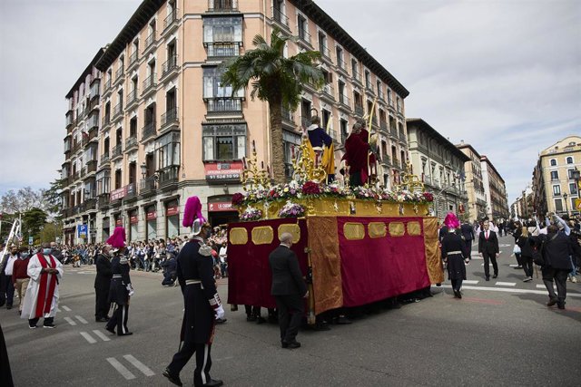 Numerosas personas atienden el paso de la Imagen de Jesús con la Borriquita, por el centro de Madrid, a 10 de abril de 2022.