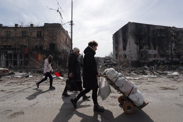 Ciudadanos de Mariúpol caminan entre edificios destruidos. V Ictor/ Xinhua News/ Contacto Photo
