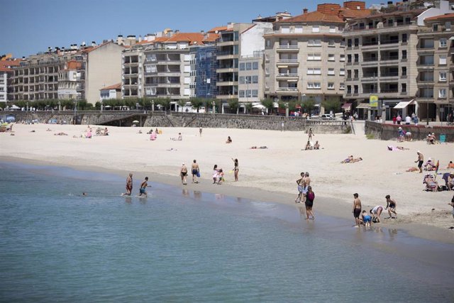 Archivo - Varias personas disfrutan de la playa de Sanxenxo, a 4 de junio de 2021