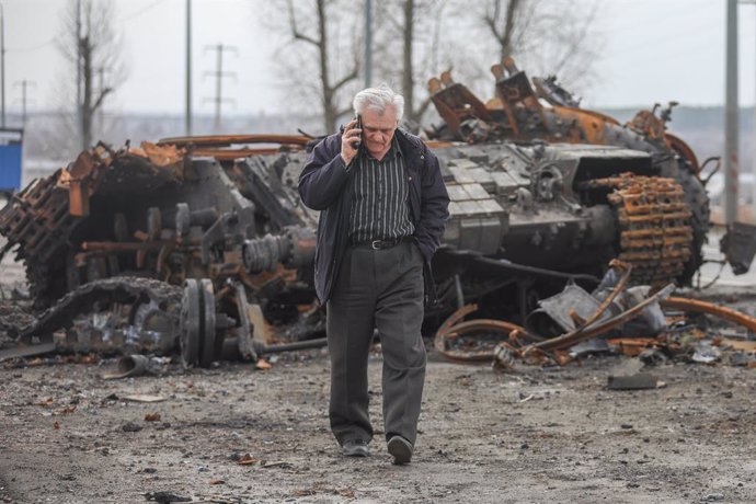 01 April 2022, Ukraine, Kharkiv: A man talking over his phone while walks past a destroyed tank after Russian shelling in the Soltavka district. Photo: Aziz Karimov/ZUMA Press Wire Service/dpa