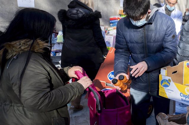 Archivo - Personas en riesgo de exclusión acuden a recoger alimentos de la Fundación Madrina, en la plaza de San Amaro, a 7 de enero de 2022, en Madrid (España). 