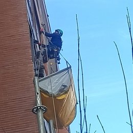 Un trabajador realiza trabajos en una fachada