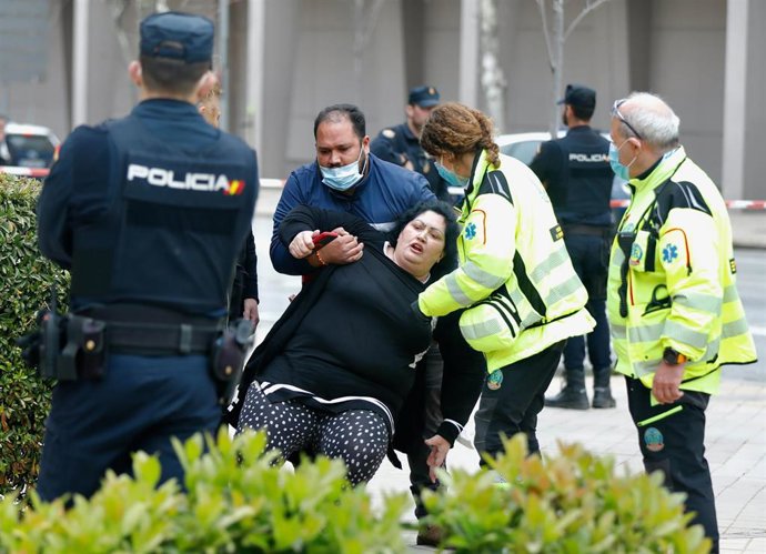 Un agente de Policía Nacional, personal del SAMUR y dos personas en las inmediaciones de la plaza de Alsacia, lugar donde ha ocurrido un accidente en el que ha muerto un conductor tras ser tiroteado desde otro vehículo, en el distrito de San Blas-Canill