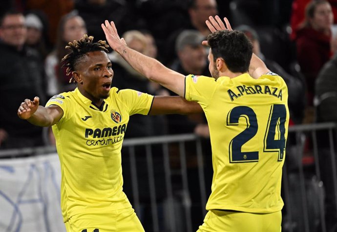 12 April 2022, Bavaria, Munich: Villareal's Samuel Chimerenka Chukwueze (L) celebrates scoring his side's first goal with team mate Alfonso Pedraza Sag during the UEFA Champions League Quarter-final second leg soccer match between FC Bayern Munich and V