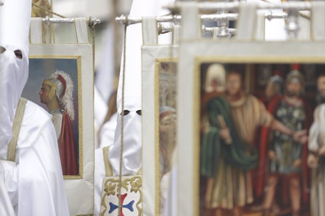 Un nazareno porta un estandarte de la cofradía de Nuestro Padre Jesús Cautivo en la Semana Santa22. 