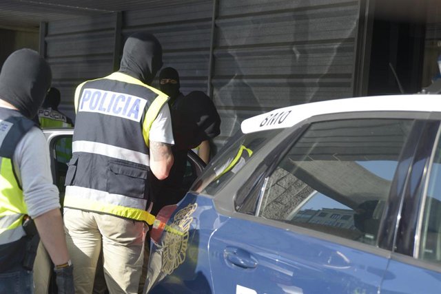 Archivo - Un agente con uno de los detenidos por el crimen de Samuel Luiz