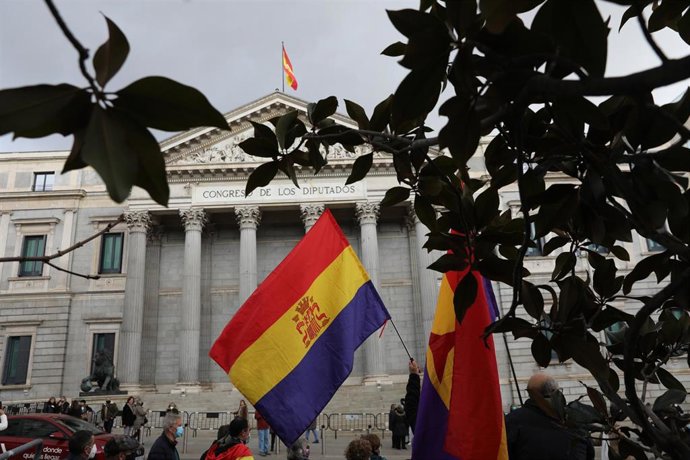 Archivo - Dos hombres sostienen banderas de la República y de las Brigadas Internacionales, durante una manifestación por los derechos de las víctimas del franquismo, frente al Congreso de los Diputados, a 10 de diciembre de 2021, en Madrid (España).¡