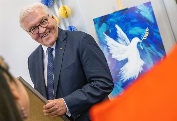 12 April 2022, Poland, Warsaw: German President Frank-Walter Steinmeier stands in front of a picture of a peace dove during a visit to young volunteers of Caritas Poland. Steinmeier is in Poland to discuss the Russian aggression on Ukraine. Photo: Jens 