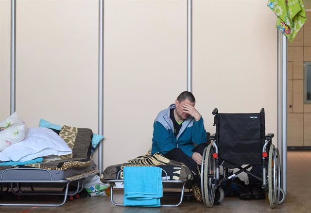 13 April 2022, Saxony, Dresden: Viktor, who fled the Ukrainian city of Bela Tserkva, sits next to his wheelchair in the gymnasium of the Buergerwiese high school, which is currently being used as an emergency shelter for refugees from Ukraine.