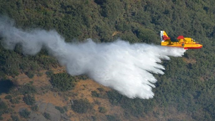 Archivo - Imagen de archivo de un avión descargando agua para sofocar el fuego en un incendio forestal
