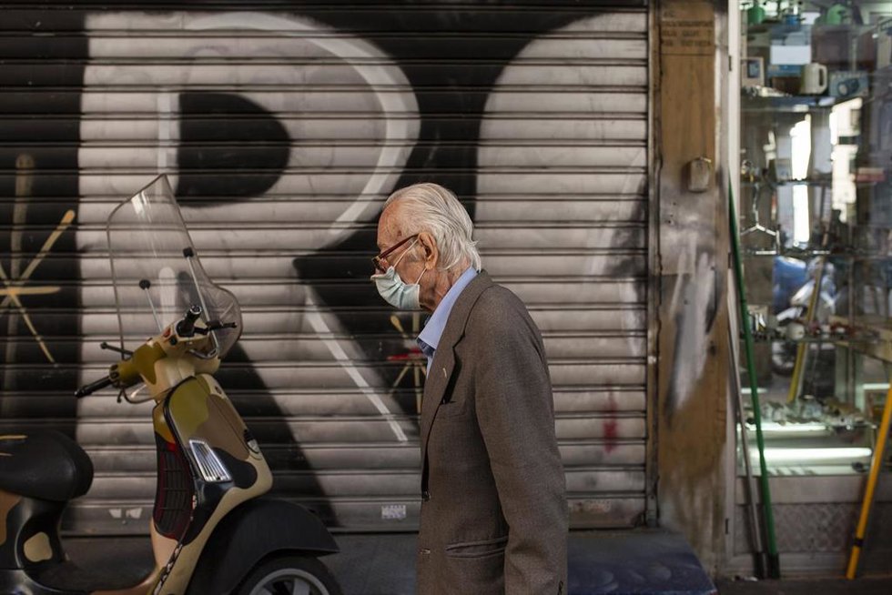 Archivo - Un hombre pasea con mascarilla por Atenas, Grecia. 