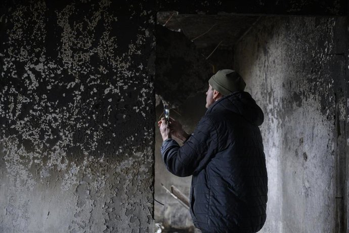 Un hombre toma fotos en una vivienda quemada en Kiev.