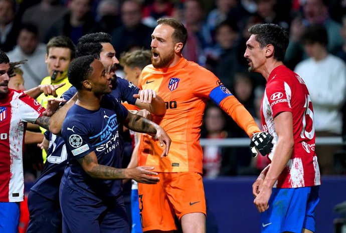 13 April 2022, Spain, Madrid: Atletico Madrid goalkeeper Jan Oblak (C) steps in between Stefan Savic and Manchester City's Raheem Sterling as tempers flare during the UEFA Champions League Quarter-final second leg soccer match between Atletico Madrid an