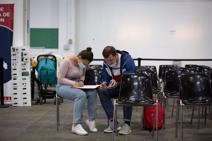 Dues persones refugiades ucraneses en una sala d'espera del centre de refugiats ucranesos, a la Fira de Barcelona
