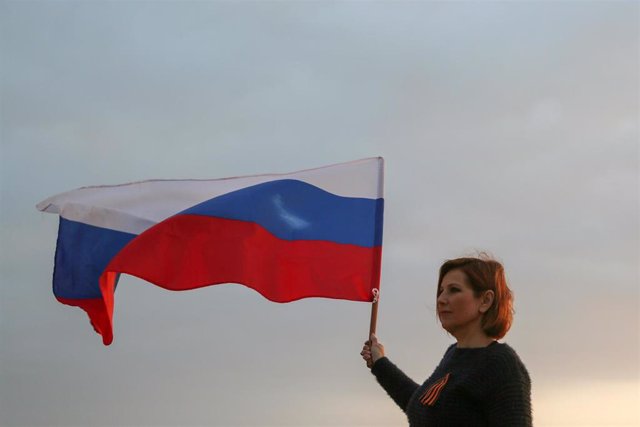 Una mujer ondea una bandera rusa en Beirut, la capital de Líbano. 