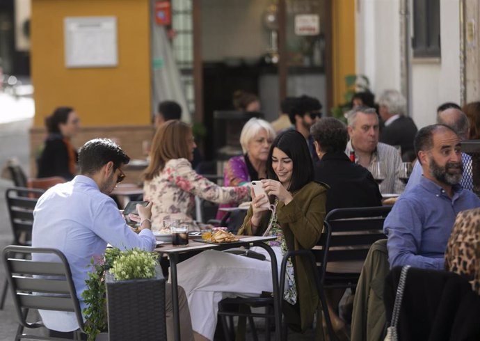 Archivo - Personas en la terraza de un bar en Sevilla 