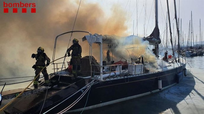 Els Bombers treballen en l'incendi d'un vaixell recreatiu en el Port de Badalona (Barcelona)