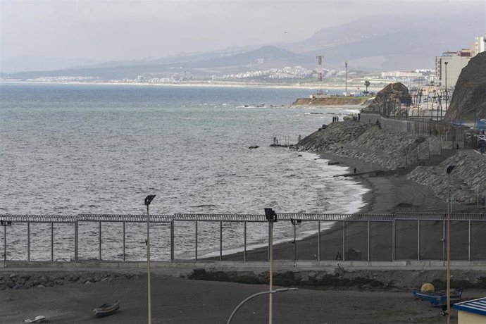 Archivo - Personas (al fondo), instalan una valla en la playa del Tarajal, a 24 de junio de 2021, en Marruecos. El pasado 1 de junio Marruecos comenzó a instalar concertinas en su lado del espigón de la playa del Tarajal. Sin embargo, no ha sido hasta h