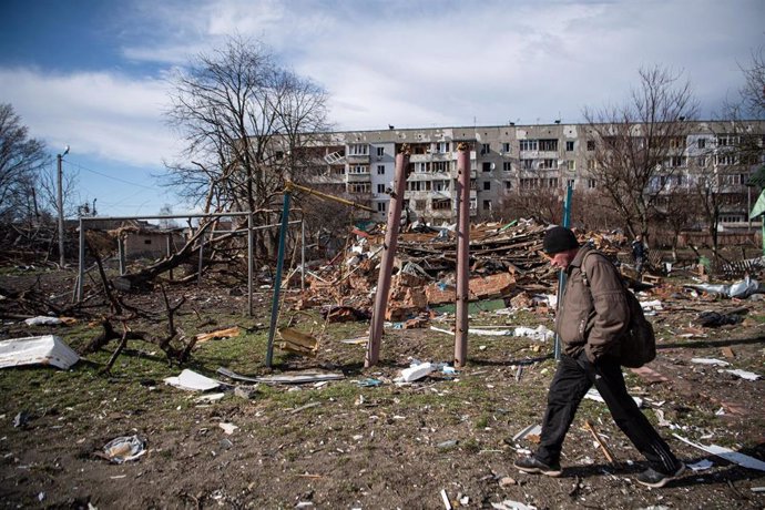 Un hombre junto a un edificio dañado por los combates en la región de Kiev