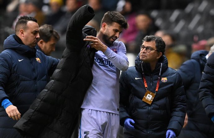 07 April 2022, Hessen, Frankfurt/M.: Barcelona's Gerard Pique puts on a jacket after leaving the pitch with an injury during the UEFA Europa League quarterfinal first leg soccer match between Eintracht Frankfurt and FC Barcelona at Deutsche Bank Park. P