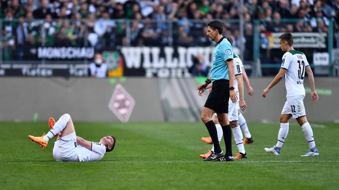 16 April 2022, North Rhine-Westphalia, Monchengladbach: Referee Deniz Aytekin talks to Moenchengladbach's Matthias Ginter (L) after Cologne's third goal during the German Bundesliga soccer match between Borussia Moenchengladbach and 1. FC Cologne at Bor