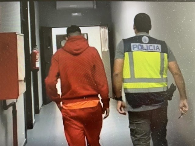 Un agente de la Policía Nacional con el detenido