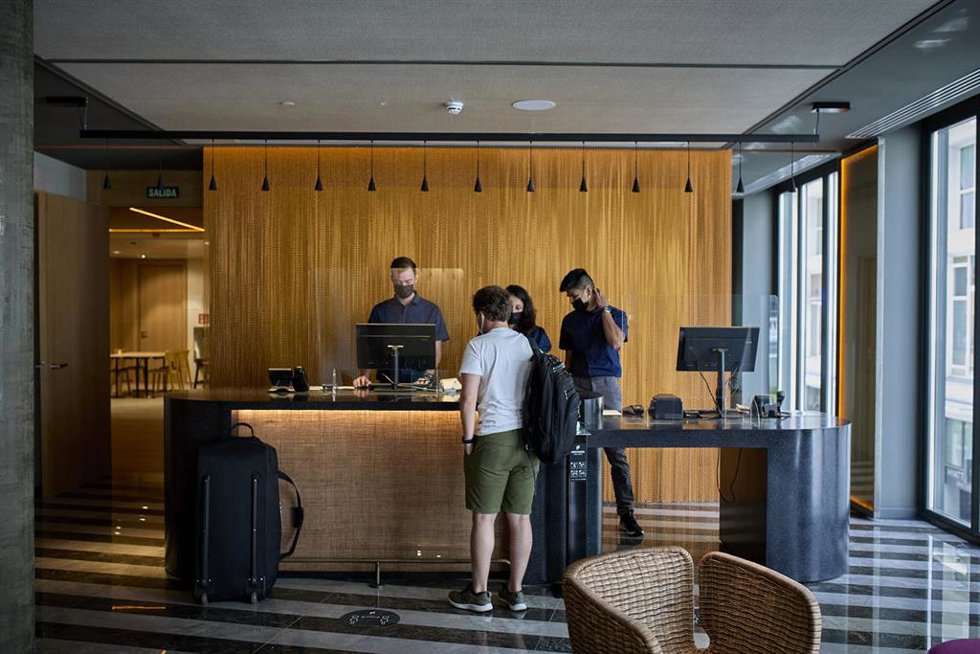 Archivo - Varios huéspedes en la recepción de un hotel.  