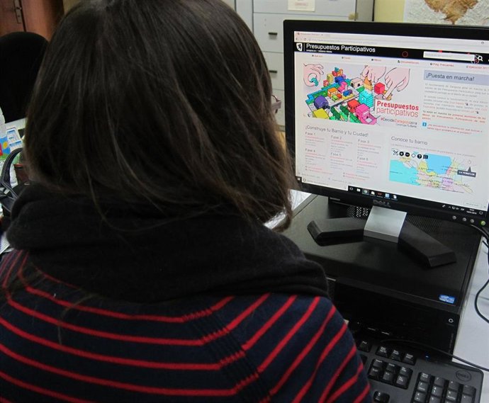 Archivo - Una joven consulta la página de los presupuestos participativos de Zaragoza