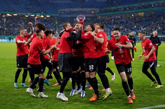 19 April 2022, Hamburg: Freiburg players celebrate victory after the German DFB Cup semi-final soccer match between Hamburger SV and SC Freiburg at the Volksparkstadion. Photo: Marcus Brandt/dpa - IMPORTANT NOTICE: DFL and DFB regulations prohibit any u