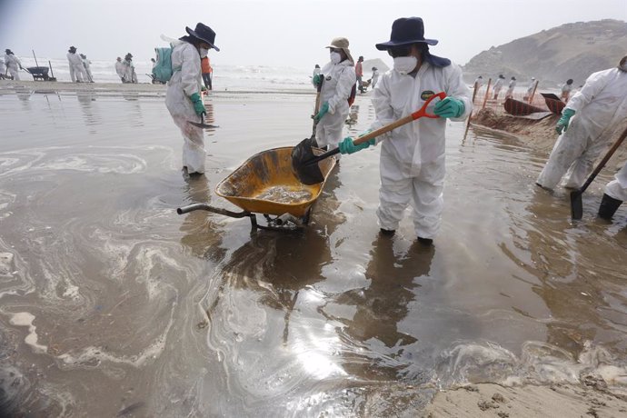 Archivo - FILED - 27 January 2022, Peru, Ventanilla: Units work to clean up the oil spill at Cavero beach after about 6,000 barrels (159 liters each) of oil spilled during the unloading of a tanker at the La Pampilla refinery owned by Spanish energy com
