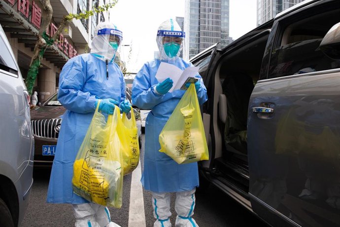 Dos personas con trajes EPI en Shanghái