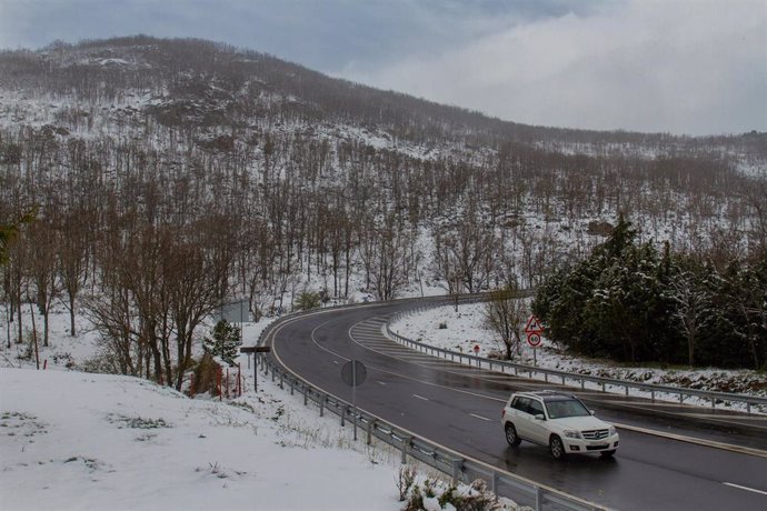 Un vehículo circula por una carretera de Guadarrama con nieve a su alrededor, a 20 de abril de 2022, en Guadarrama, Madrid (España). Madrid ha activado el Plan de Inclemencias Invernales por nieve, lluvias y viento que han provocado atascos kilométricos