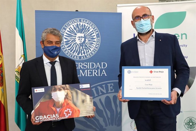 El rector Carmelo Rodríguez entrega lo recaudado a Diego Ortiz, de Cruz Roja