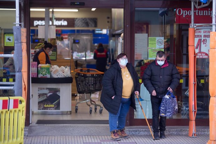 Archivo - Un hombre y una mujer salen de un supermercado en el municipio gallego de Guitiriz, en Lugo