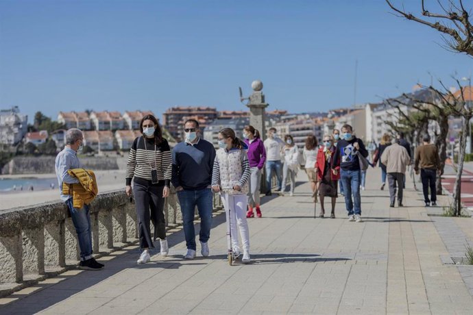 Archivo - Varias personas caminan por un paseo marítimo en Sanxenxo, Pontevedra, Galicia (España), a 21 de marzo de 2021. El pasado miércoles el Ministerio de Sanidad y las Comunidades Autónomas acordaron una serie de medidas a aplicar durante el puente
