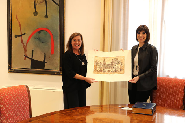 La presidenta del Govern, Francina Armengol (i) y la ministra de Ciencia e Innovación, Diana Morant (d), posan con una litografía de la fachada del Consolat de Mar.