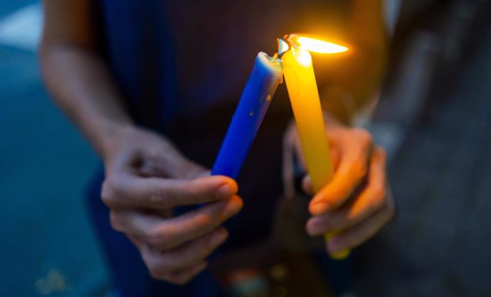24 March 2022, Brazil, Sao Paulo: A member of the Ukrainian community lights candles during a vigil in Sao Paulo to protest against the Russian invasion of Ukraine. Photo: Cris Faga/ZUMA Press Wire/dpa