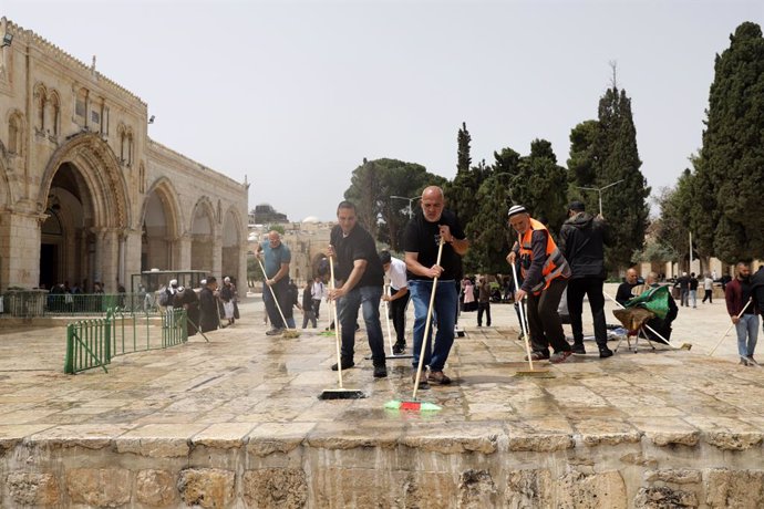 17 April 2022, Israel, Jerusalem: Palestinians clean Al-Aqsa mosque following clashes with Israeli security forces in Jerusalem's Old City. Photo: Jeries Bssier/APA Images via ZUMA Press Wire/dpa