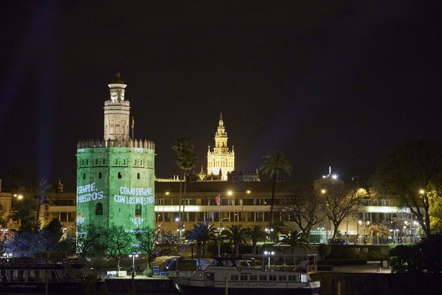 La Torre del Oro iluminada con el escudo del Betis