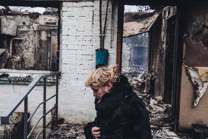 Archivo - Una mujer frente a su casa destruida por las bombas, a 5 de marzo de 2022, en Irpin (Ucrania).