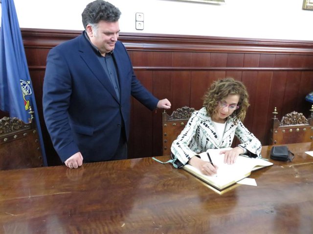 La ministra de Hacienda y Función Pública, María Jesús Montero, firma el libro de honor del Ayuntamiento, junto al alcalde de Morón, Juan Manuel Rodríguez, en el Consistorio.