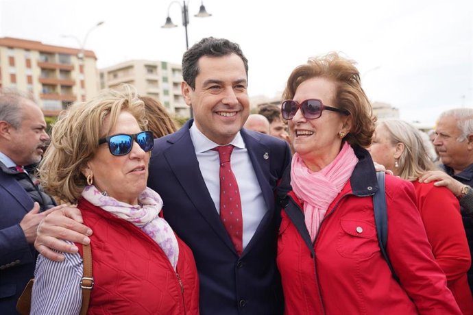 Juanma Moreno con dos vecinas de Adra (Almería) antes de inagurar el muelle gourmet del puerto pesquero