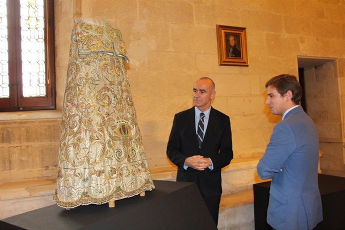 El alcalde de Sevilla, junto a una de las sayas de Virgen confeccionadas con un traje de luces de Pepe Luis Vázquez, que forma parte de la muestra en el Ayuntamiento.