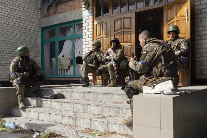 28 March 2022, Ukraine, Rudnyts'ke: Ukrainian soldiers rest at the entrance of a school. The school was the headquarters of the Russian military in the town before the Ukrainian Army retook control of the area on the morning of the 28th of March. Photo: