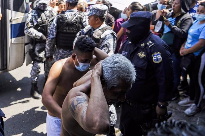 Policías escoltan a supuestos pandilleros en El Salvador.
